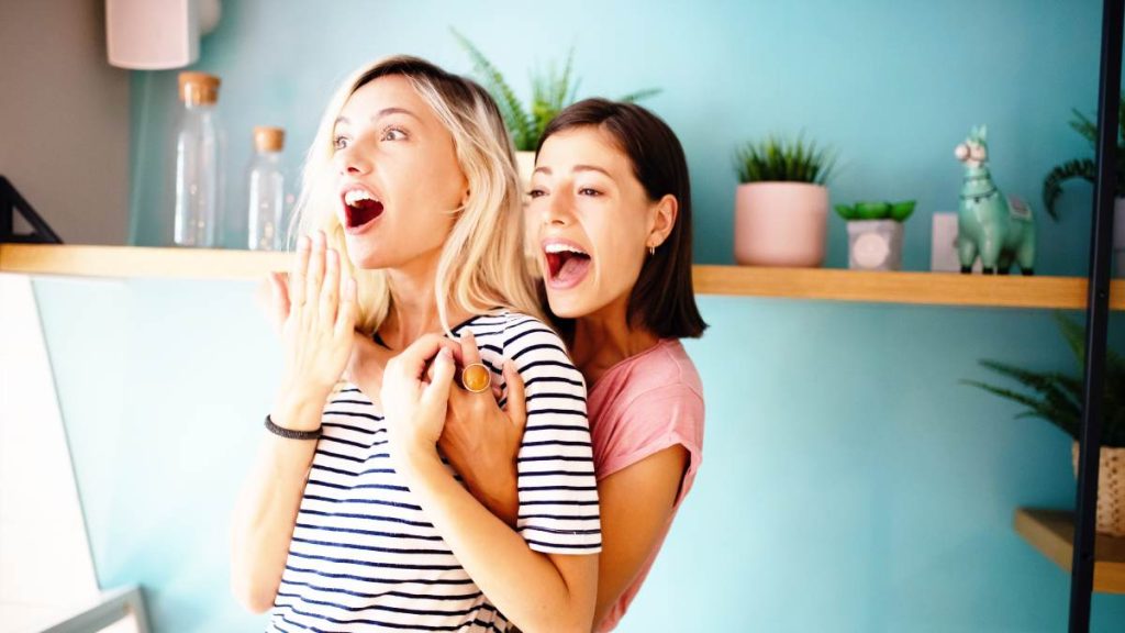 Deux colocatrices échangent un cadeau sensuel dans une ambiance intimiste et glamour