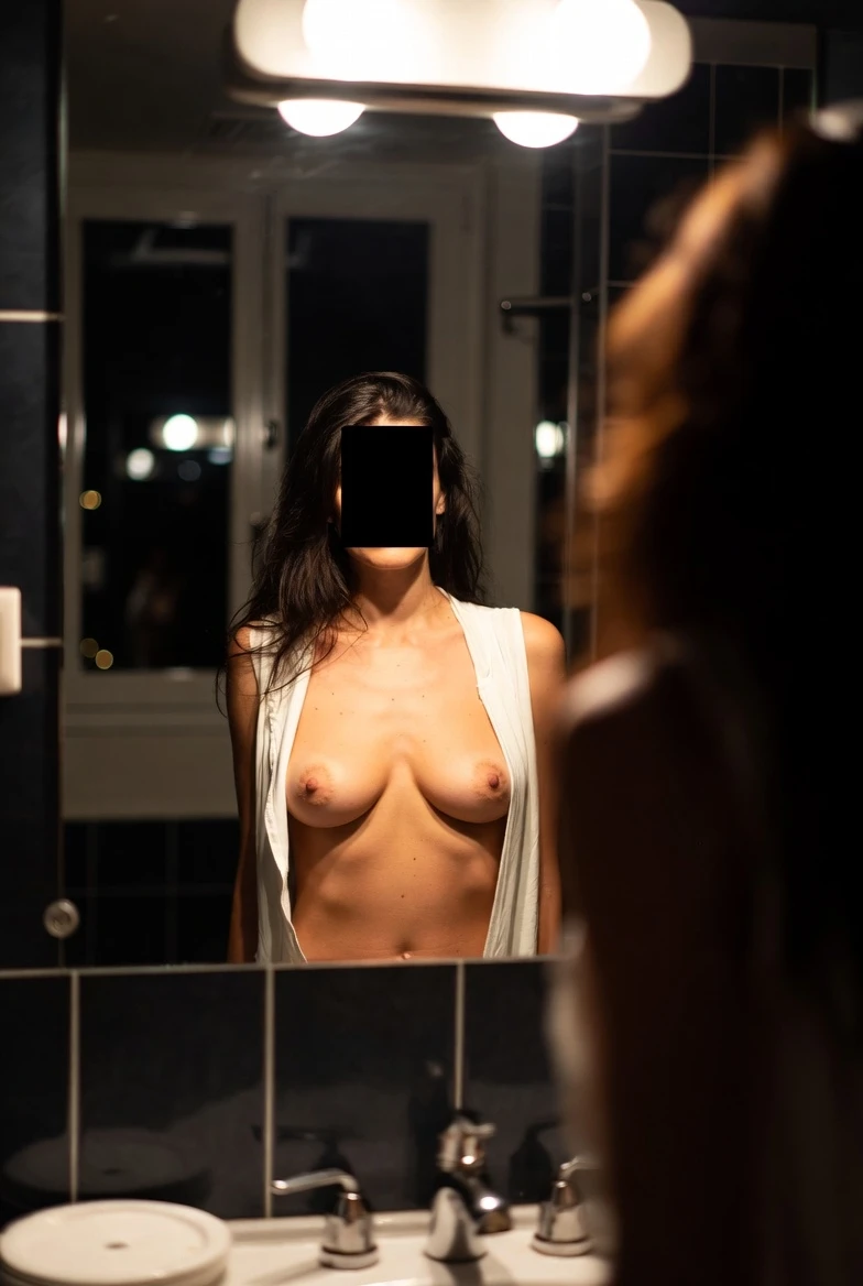 Femme devant miroir de salle de bain, reflet de ses seins nus, lumière tamisée